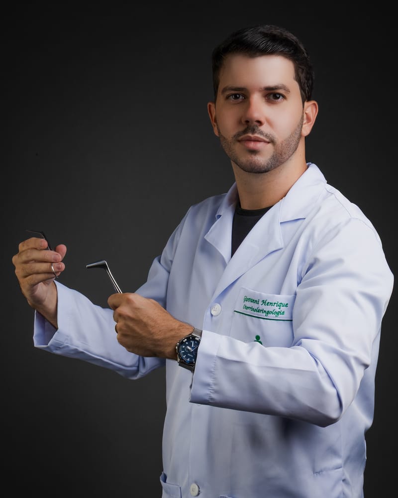 Dr. Giovanni Henrique de jaleco, com instrumentos de otorrinolaringologia